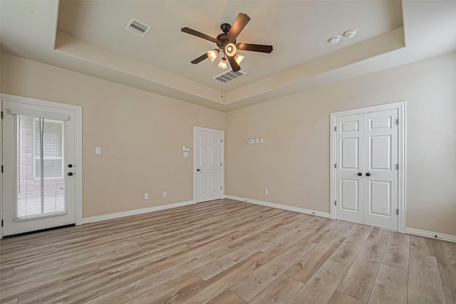 5442 Jackson Park Ln, Katy, TX 77494 - empty room with a raised ceiling, ceiling fan, light wood-style flooring, baseboards, and a smoke detector