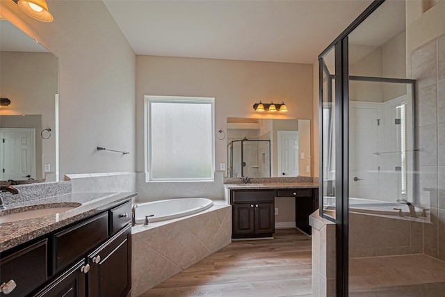 5442 Jackson Park Ln, Katy, TX 77494 - bathroom with a stall shower, a bath, two vanities, and wood finished floors