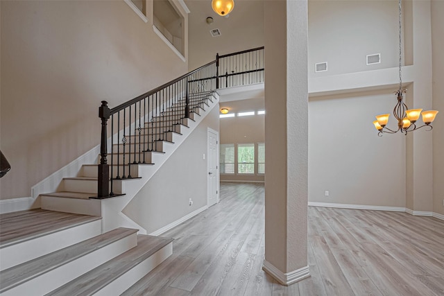 5442 Jackson Park Ln, Katy, TX 77494 - stairway with a high ceiling, wood finished floors, a chandelier, and baseboards