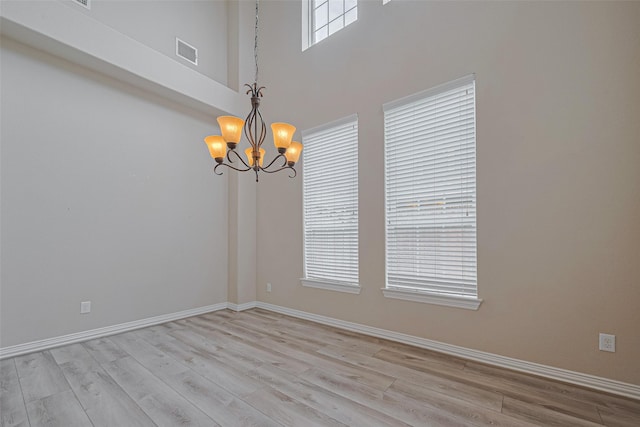 5442 Jackson Park Ln, Katy, TX 77494 - empty room featuring a chandelier, light wood-type flooring, baseboards, and a towering ceiling