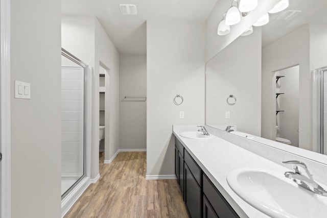 18061 Atwood Mill Dr, New Caney, TX 77357 - bathroom featuring toilet, wood finished floors, double vanity, a stall shower, and baseboards