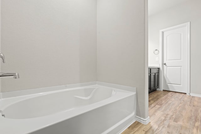 18061 Atwood Mill Dr, New Caney, TX 77357 - full bath with a bath, wood finished floors, baseboards, and vanity