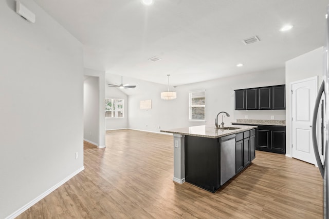 18061 Atwood Mill Dr, New Caney, TX 77357 - kitchen featuring stainless steel dishwasher, a sink, dark cabinets, light wood-style floors, and recessed lighting