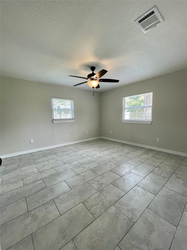 527 W 4th St, Freeport, TX 77541 - unfurnished room with plenty of natural light, a ceiling fan, baseboards, and a textured ceiling