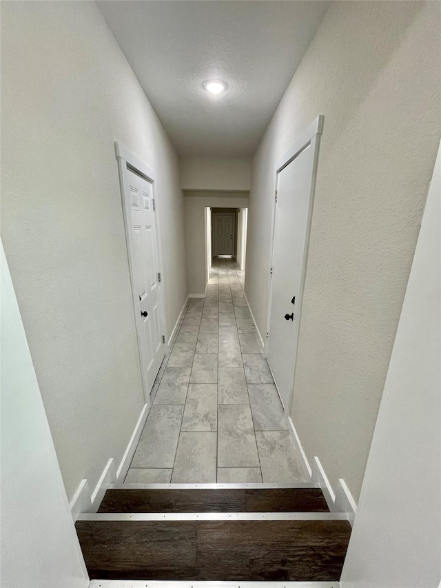 527 W 4th St, Freeport, TX 77541 - hallway featuring baseboards, light marble finish floors, and a textured wall