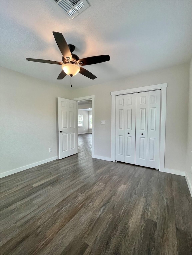 527 W 4th St, Freeport, TX 77541 - unfurnished bedroom with dark wood-style floors, baseboards, ceiling fan, and a closet