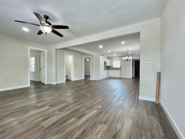 527 W 4th St, Freeport, TX 77541 - unfurnished living room featuring a chandelier, dark wood-style floors, ceiling fan, baseboards, and a textured ceiling