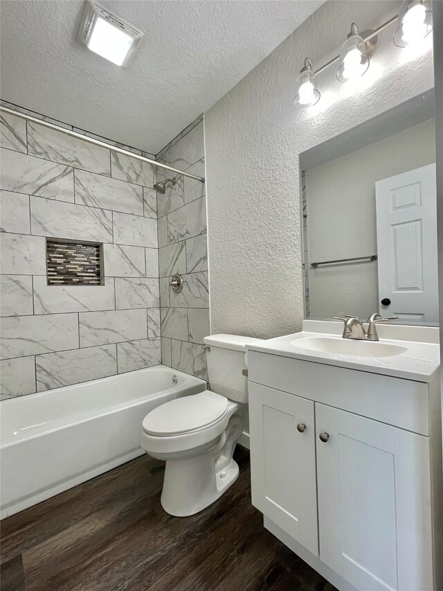 527 W 4th St, Freeport, TX 77541 - bathroom featuring a textured wall, a textured ceiling, vanity, wood finished floors, and toilet