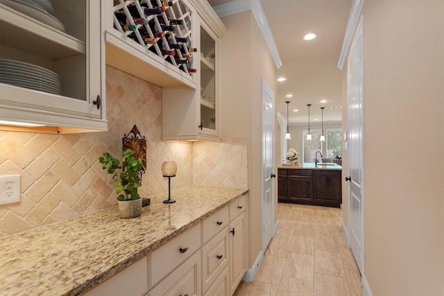 19023 Wild Thornberry Dr, Tomball, TX 77377 - kitchen with backsplash, light stone counters, glass insert cabinets, a sink, and ornamental molding