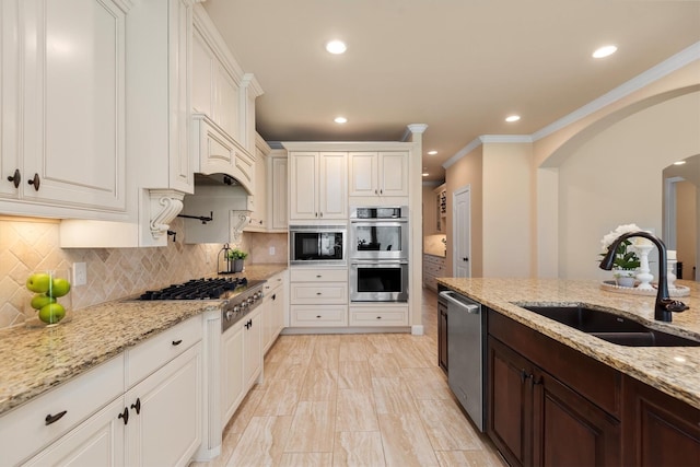 19023 Wild Thornberry Dr, Tomball, TX 77377 - kitchen with a sink, appliances with stainless steel finishes, tasteful backsplash, ornamental molding, and white cabinetry