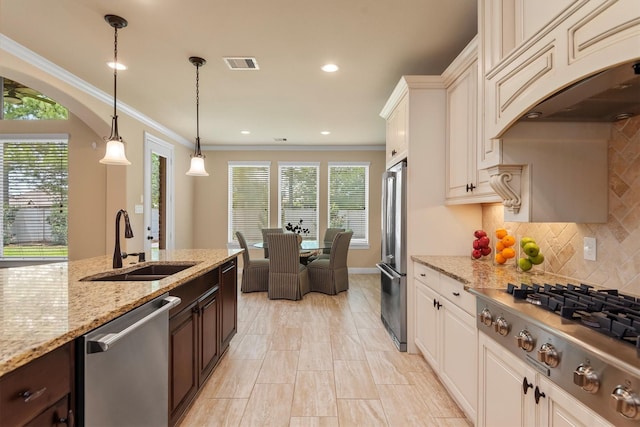 19023 Wild Thornberry Dr, Tomball, TX 77377 - kitchen with stainless steel appliances, a sink, dark brown cabinetry, plenty of natural light, and crown molding
