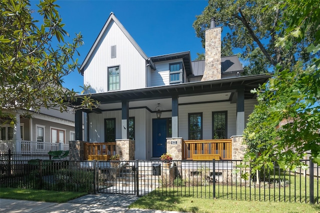 711 E 12th St, Houston, TX 77008 - view of front of property featuring a porch, a fenced front yard, a chimney, and metal roof