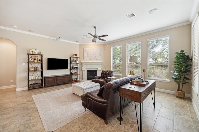 21307 Plum Gate Ct, Richmond, TX 77407 - living room featuring arched walkways, crown molding, ceiling fan, a glass covered fireplace, and baseboards