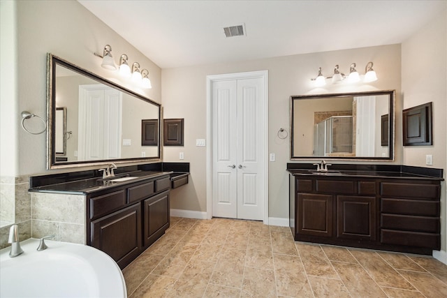 21307 Plum Gate Ct, Richmond, TX 77407 - full bath with a stall shower, two vanities, a bath, and baseboards