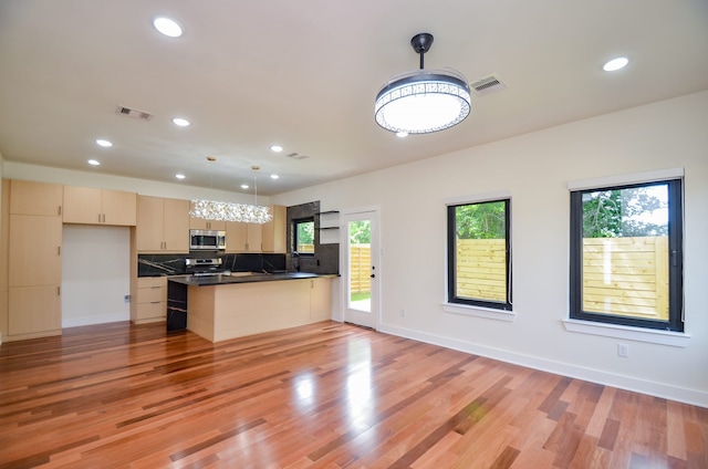 3626 Dreyfus St, Houston, TX 77021 - kitchen featuring stainless steel appliances, a peninsula, recessed lighting, dark countertops, and light wood-type flooring