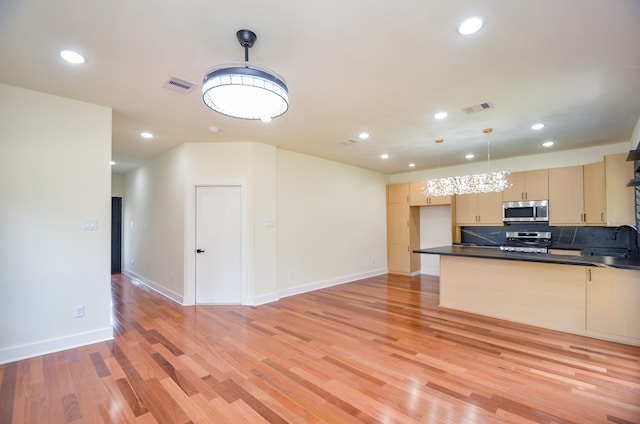 3626 Dreyfus St, Houston, TX 77021 - kitchen with appliances with stainless steel finishes, dark countertops, light brown cabinetry, a sink, and recessed lighting