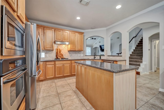 17815 Gables Bend Dr, Tomball, TX 77377 - kitchen featuring appliances with stainless steel finishes, a sink, a kitchen island, decorative backsplash, and crown molding