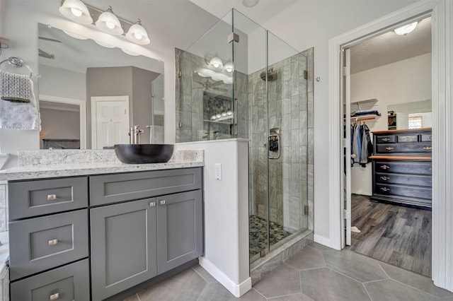 17815 Gables Bend Dr, Tomball, TX 77377 - bathroom with a walk in closet, vanity, tile patterned floors, a stall shower, and baseboards