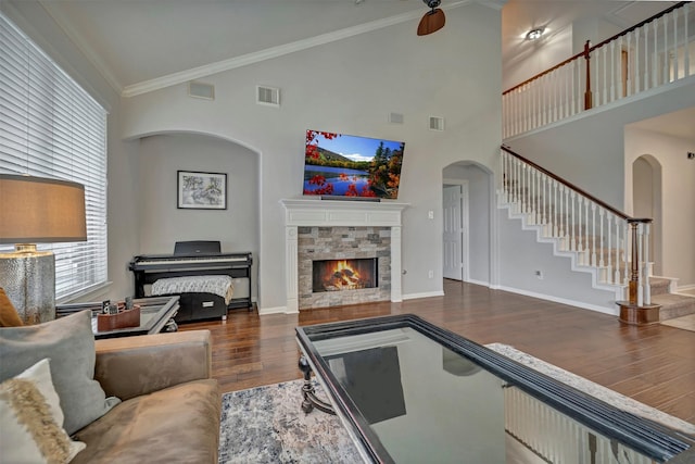 17815 Gables Bend Dr, Tomball, TX 77377 - living area featuring wood finished floors, arched walkways, stairs, high vaulted ceiling, and a tiled fireplace
