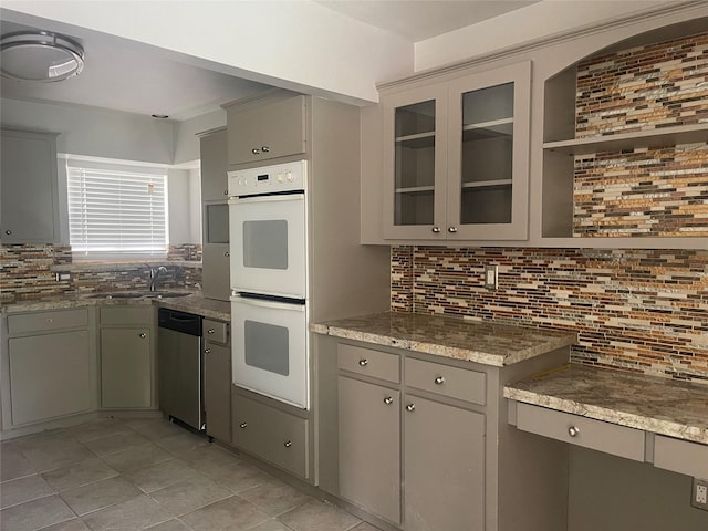623 E Canino Rd, Houston, TX 77037 - kitchen featuring stainless steel dishwasher, double oven, gray cabinets, and decorative backsplash