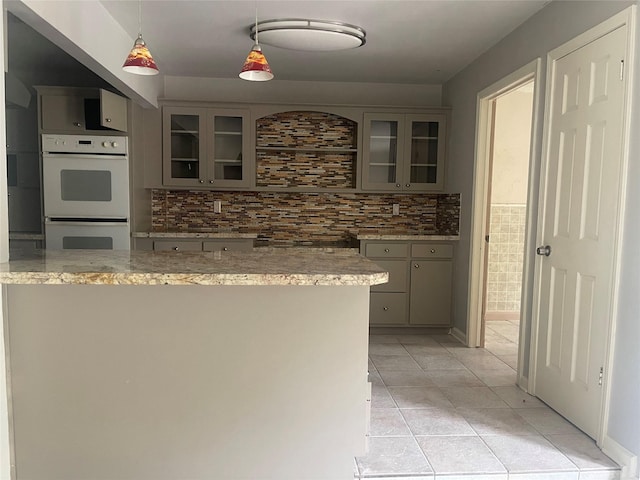 623 E Canino Rd, Houston, TX 77037 - kitchen featuring double oven, backsplash, light tile patterned floors, and glass insert cabinets