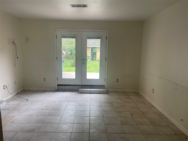 623 E Canino Rd, Houston, TX 77037 - empty room featuring french doors, light tile patterned floors, and baseboards