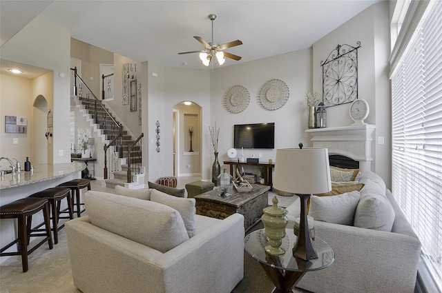 13705 Northline Lake Dr, Houston, TX 77044 - living room with arched walkways, a ceiling fan, a fireplace, and stairway