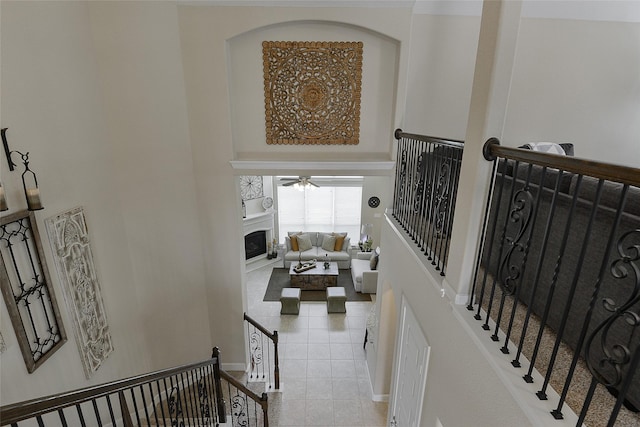 13705 Northline Lake Dr, Houston, TX 77044 - stairway featuring a fireplace, ceiling fan, tile patterned flooring, and baseboards