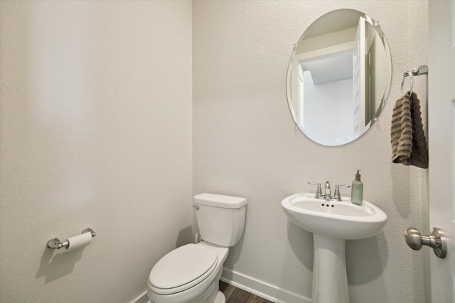9954 Storehouse Dr, Houston, TX 77080 - bathroom featuring toilet, baseboards, and wood finished floors