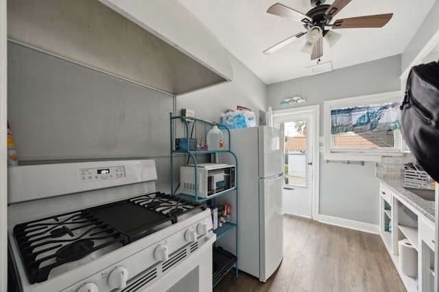 4404 Avenue N 1/2 Ave N 1/2, Galveston, TX 77550 - kitchen with white appliances, wood finished floors, ceiling fan, and baseboards