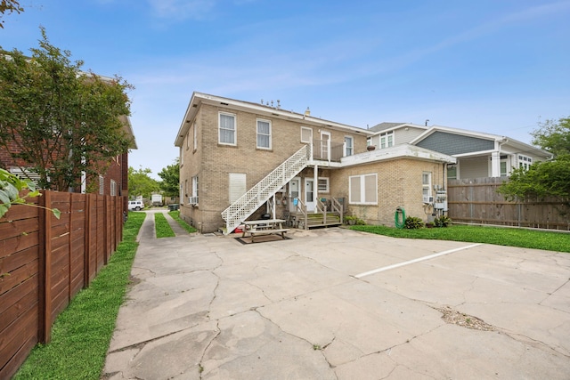4404 Avenue N 1/2 Ave N 1/2, Galveston, TX 77550 - back of house featuring brick siding, a patio, and stairs