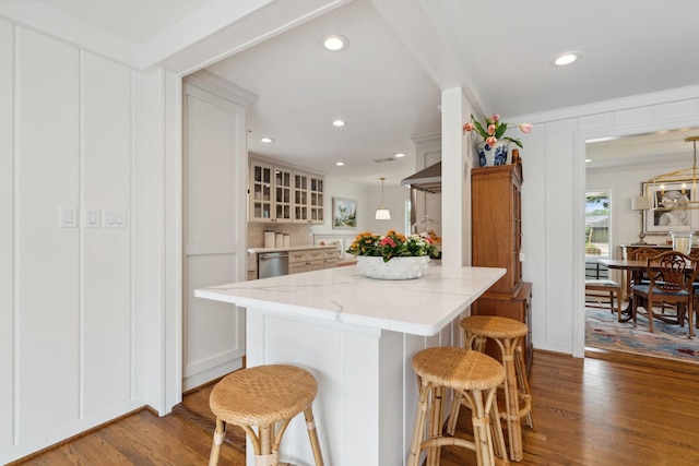6147 Chevy Chase Dr, Houston, TX 77057 - kitchen featuring wood finished floors, a kitchen breakfast bar, ornamental molding, light stone counters, and decorative light fixtures