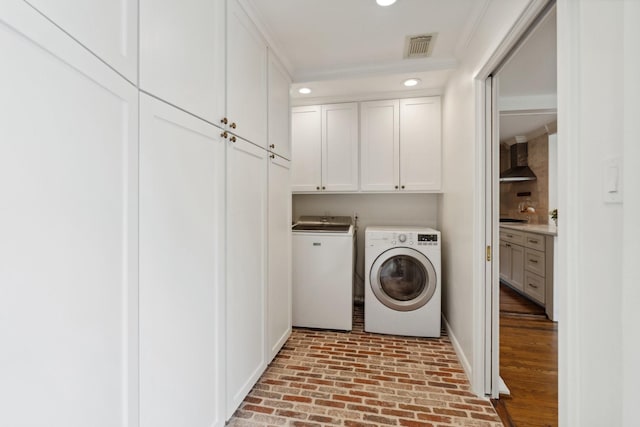 6147 Chevy Chase Dr, Houston, TX 77057 - laundry area with cabinet space, brick patterned flooring, baseboards, washing machine and dryer, and recessed lighting