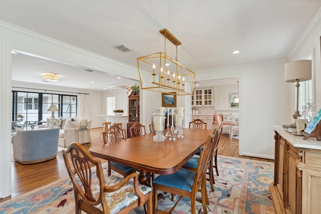 6147 Chevy Chase Dr, Houston, TX 77057 - dining area with light wood finished floors, crown molding, and recessed lighting
