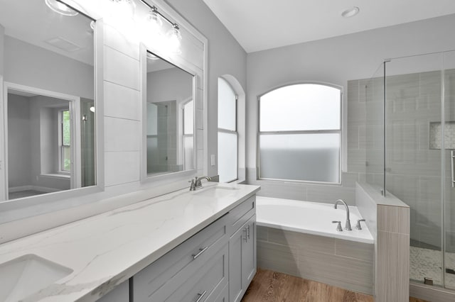 10 Hollylaurel Dr, The Woodlands, TX 77382 - full bathroom featuring double vanity, a bath, a stall shower, and wood finished floors