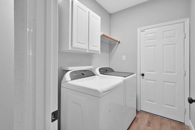 10 Hollylaurel Dr, The Woodlands, TX 77382 - laundry area featuring washing machine and clothes dryer, cabinet space, and wood finished floors