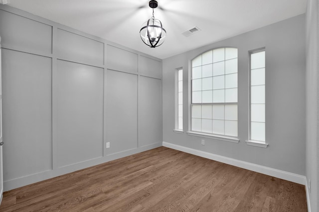 10 Hollylaurel Dr, The Woodlands, TX 77382 - spare room featuring baseboards, a chandelier, and light wood-style floors