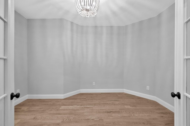 10 Hollylaurel Dr, The Woodlands, TX 77382 - unfurnished room featuring a chandelier, light wood-type flooring, and baseboards