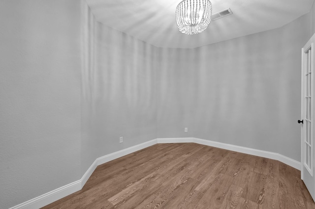 10 Hollylaurel Dr, The Woodlands, TX 77382 - unfurnished room featuring wood finished floors, a chandelier, and baseboards