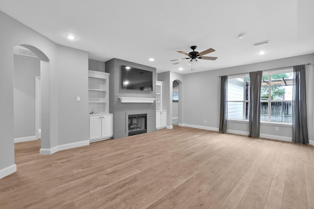 10 Hollylaurel Dr, The Woodlands, TX 77382 - unfurnished living room with arched walkways, a ceiling fan, light wood-style floors, baseboards, and recessed lighting