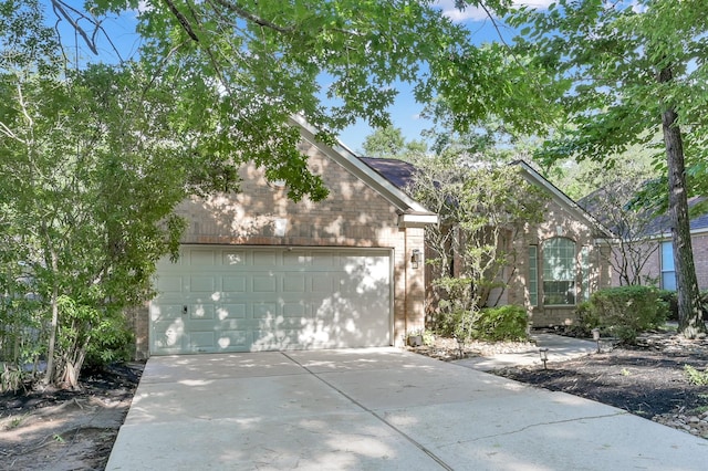 10 Hollylaurel Dr, The Woodlands, TX 77382 - view of front of home with driveway, an attached garage, and brick siding
