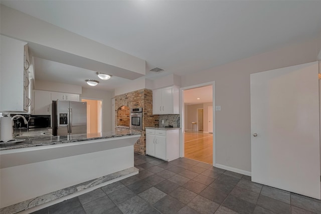 10126 Whiteside Ln, Houston, TX 77043 - kitchen with stainless steel appliances, a sink, decorative backsplash, and white cabinets