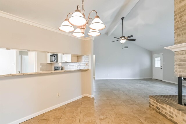 10901 Mesquite Dr, La Porte, TX 77571 - kitchen featuring stainless steel microwave, a ceiling fan, tasteful backsplash, beamed ceiling, and a chandelier