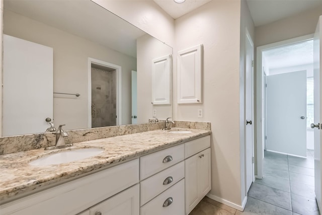 10901 Mesquite Dr, La Porte, TX 77571 - full bathroom featuring double vanity, baseboards, tile patterned flooring, and a shower