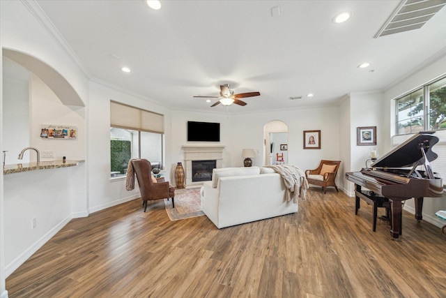 4303 Stonebrook Ln, Missouri City, TX 77459 - living area with wood finished floors, crown molding, ceiling fan, a glass covered fireplace, and recessed lighting