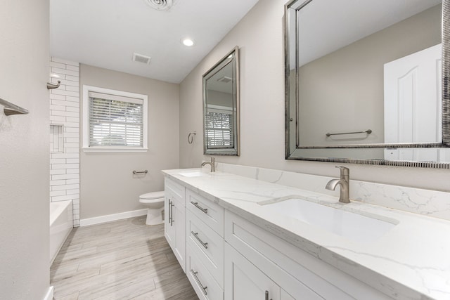 9392 Fm 1458th Rd, Sealy, TX 77474 - bathroom with double vanity, toilet, baseboards, tub / shower combination, and wood finished floors