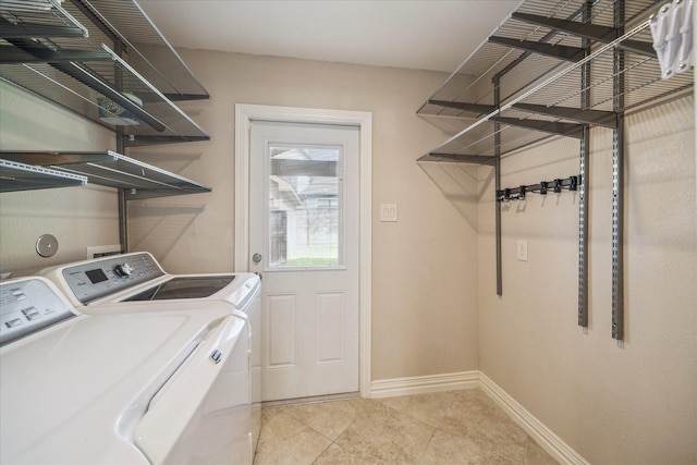 5211 W Bellfort Ave, Houston, TX 77035 - washroom with washing machine and dryer, baseboards, and light tile patterned floors