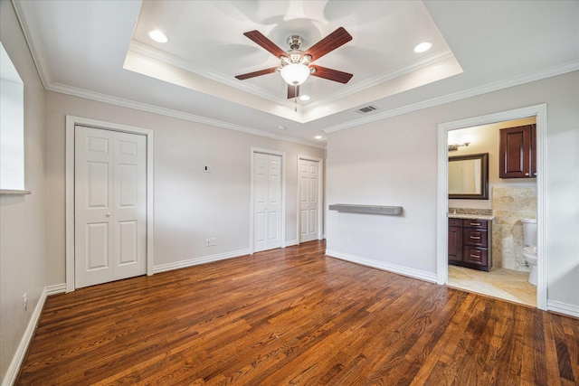 5211 W Bellfort Ave, Houston, TX 77035 - unfurnished bedroom with wood finished floors, two closets, a raised ceiling, crown molding, and baseboards