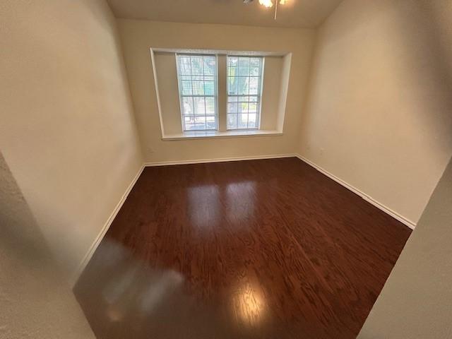 14539 Briton Cove Dr, Houston, TX 77084 - empty room featuring baseboards and dark wood-type flooring
