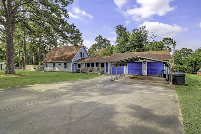 1239 Indian Hill Blvd, Livingston, TX 77351 - view of front of house with a porch, a front yard, a detached carport, and asphalt driveway